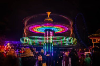 Lunaparkta hareketli bulanık renkli bir atlıkarınca, gece aydınlatması. Uzun pozlama.
