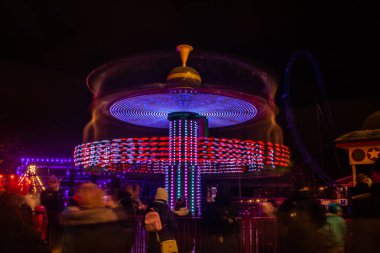Lunaparkta hareketli bulanık renkli bir atlıkarınca, gece aydınlatması. Uzun pozlama.