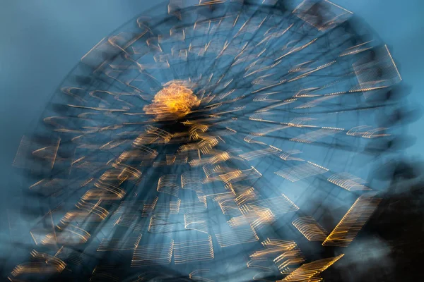 Unscharfes Riesenrad in Bewegung im Freizeitpark, nächtliche Illumination. Langzeitbelichtung. — Stockfoto