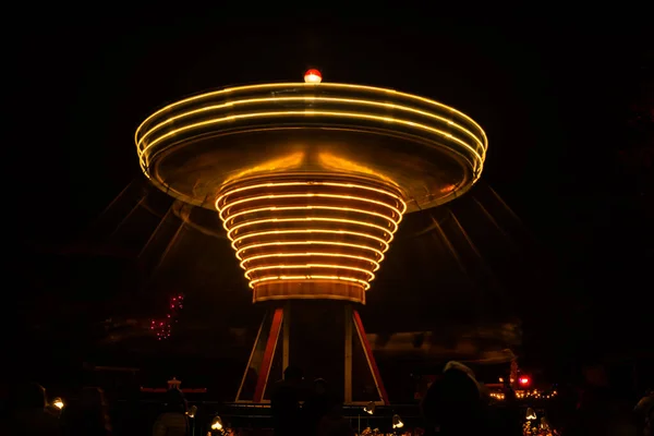 Ένα θολό πολύχρωμο καρουζέλ σε κίνηση στο λούνα παρκ, νυχτερινό φωτισμό. Μεγάλη έκθεση. — Φωτογραφία Αρχείου