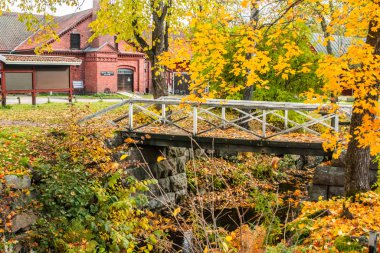 Finlandiya 'daki sisli sonbahar parkında eski ahşap köprü