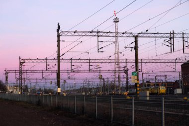 Kouvola, Finlandiya - 15 Kasım 2019: Gün batımının arka planında demiryolu.