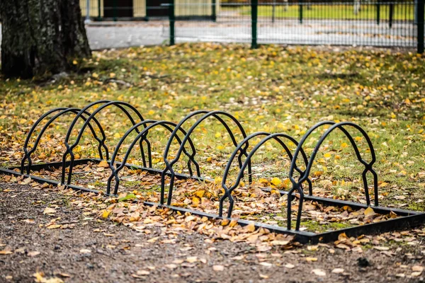 Estantes de metal para bicicletas de estacionamiento en el parque de otoño —  Fotos de Stock