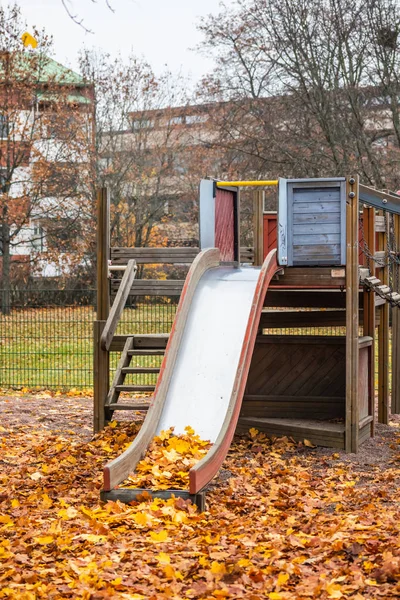 Crianças velhas vazias deslizam com folhas de bordo no dia de outono . — Fotografia de Stock