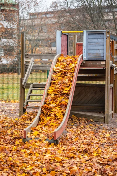 Niños viejos y vacíos se deslizan con hojas de arce en el día de otoño . — Foto de Stock