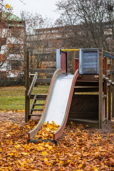 Niños viejos y vacíos se deslizan con hojas de arce en el día de otoño . — Foto de Stock