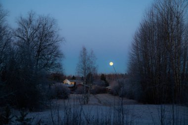 Eski ev ve dolunaylı kırsal alan.