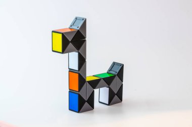 Beyaz arka planda köpek şeklinde renkli yılan yapbozu