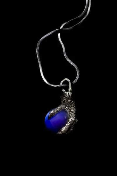 Όμορφο ασημένιο μενταγιόν σε σχήμα ποδιού πουλιού με μπλε μπάλα πέτρα και αλυσίδα που απομονώνονται σε μαύρο φόντο — Φωτογραφία Αρχείου