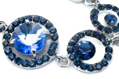 Beyaz arka planda mavi taşları olan güzel gümüş kolye.