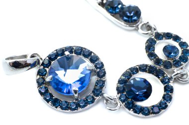 Beyaz arka planda mavi taşları olan güzel gümüş kolye.