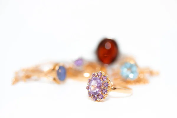 Συλλογή από κοσμήματα με όμορφο χρυσό δαχτυλίδι με μωβ πέτρα που απομονώνονται σε λευκό φόντο — Φωτογραφία Αρχείου