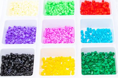 Renklere göre sıralanmış bir sürü plastik oyuncak mozaik boncuk.