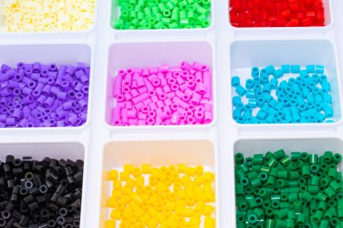 Renklere göre sıralanmış bir sürü plastik oyuncak mozaik boncuk.