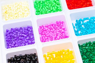 Renklere göre sıralanmış bir sürü plastik oyuncak mozaik boncuk.