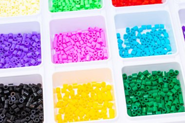 Renklere göre sıralanmış bir sürü plastik oyuncak mozaik boncuk.