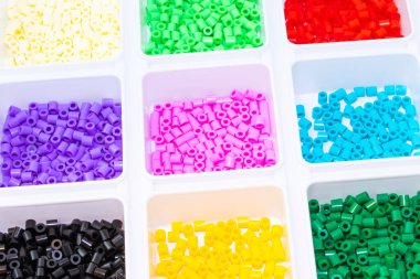 Renklere göre sıralanmış bir sürü plastik oyuncak mozaik boncuk.