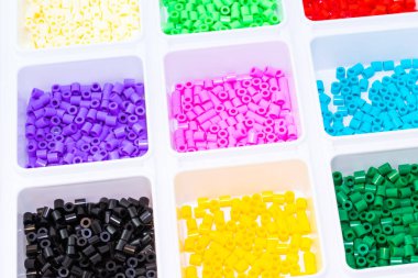 Renklere göre sıralanmış bir sürü plastik oyuncak mozaik boncuk.