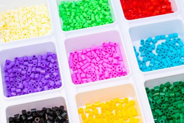 Renklere göre sıralanmış bir sürü plastik oyuncak mozaik boncuk.