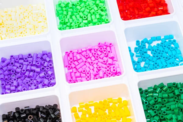 Renklere göre sıralanmış bir sürü plastik oyuncak mozaik boncuk.