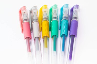 Metalik renklerde, beyaz arkaplanda izole edilmiş renkli plastik kalemler.