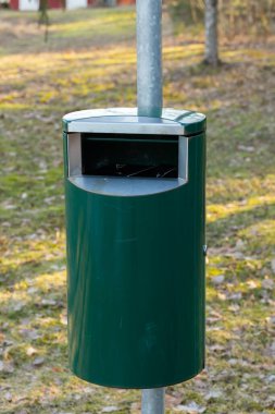 Finlandiya 'da bir parkta yeşil metal çöp kutusu