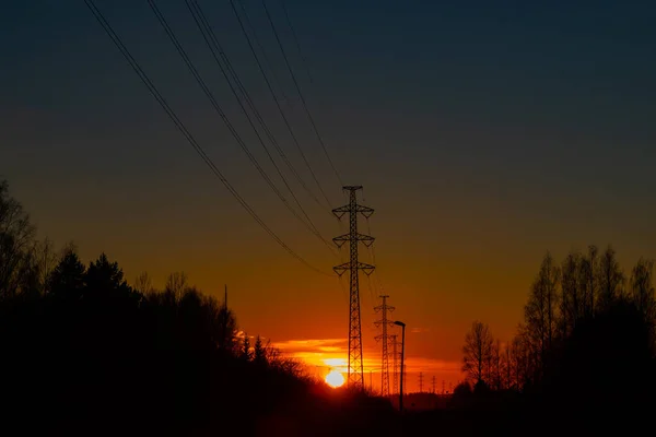 高压电塔映衬着美丽的夕阳 — 图库照片