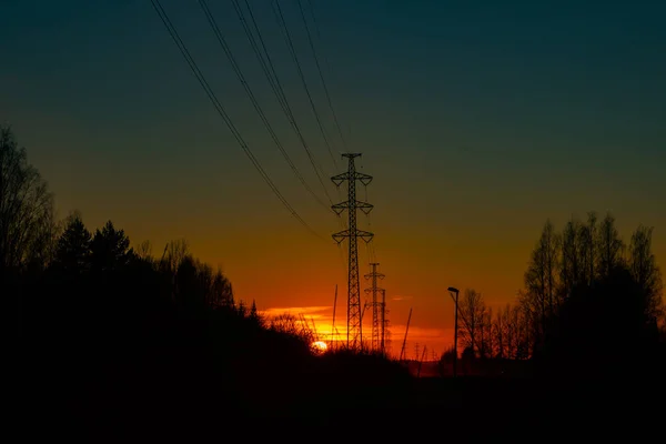 高压电塔映衬着美丽的夕阳 — 图库照片