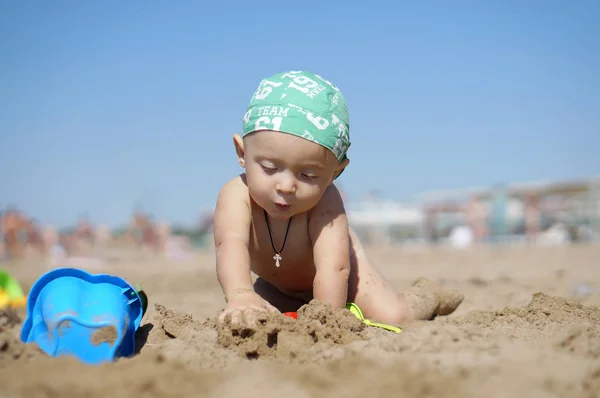 Kleiner Junge sitzt und spielt mit dem Sand — Stockfoto
