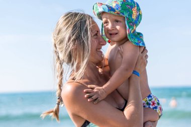 Anne ve oğlu gün zaman kumsalda oynarken       