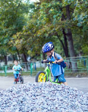 Sıcak yaz gününde üzerinde bisiklet sürme komik iki etkin küçük çocuklar. Kırsal. Etkin boş ve