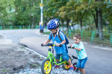 Sıcak yaz gününde üzerinde bisiklet sürme komik iki etkin küçük çocuklar. Kırsal. Aktif eğlence ve spor çocuklar için.
