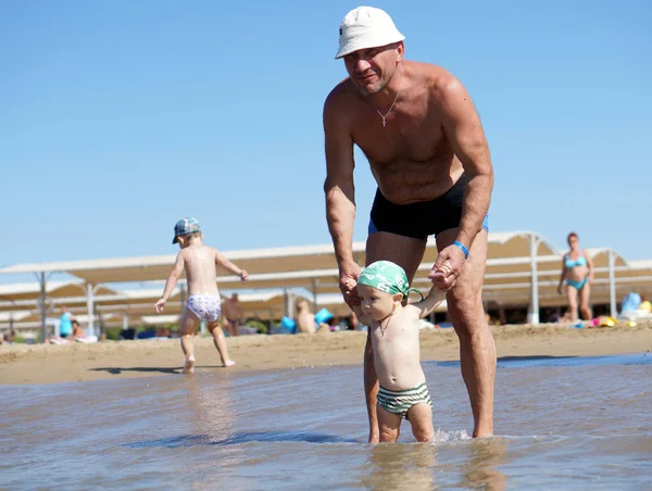 Grandfather and grandson swimming at the sea