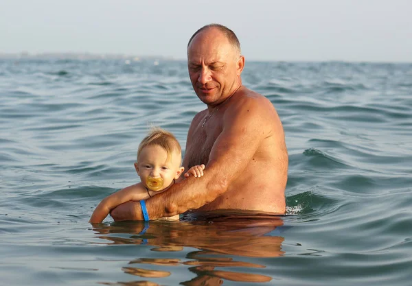 Grand-père et petit-fils nageant à la mer — Photo
