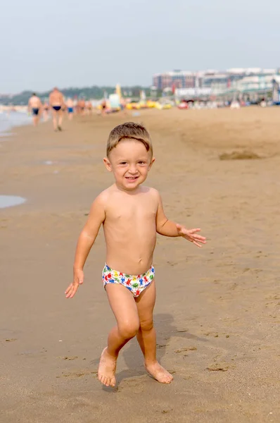 Glücklicher kleiner Junge läuft am tropischen Sandstrand — Stockfoto