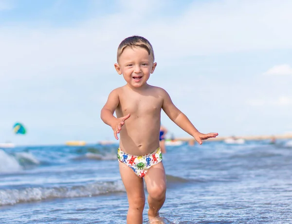 Glücklicher kleiner Junge läuft am tropischen Sandstrand — Stockfoto