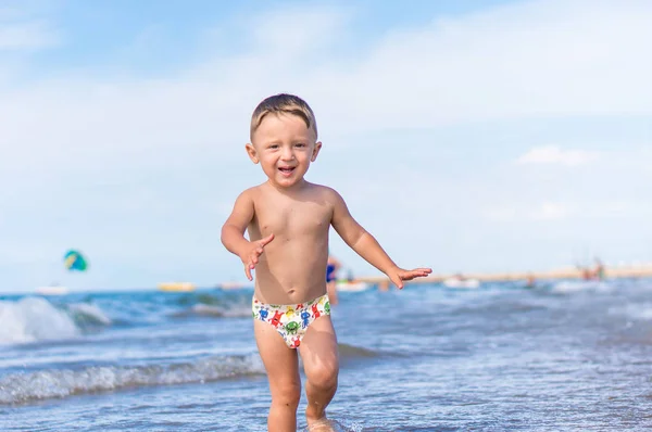 Glücklicher kleiner Junge läuft am tropischen Sandstrand — Stockfoto