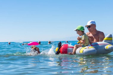 Büyükanne ve büyükbaba denizin hava uçak ile oynarken küçük bebeğim gülümseyerek. Olumlu insan duyguları, duygular, joy. Mutlu bir aile. 