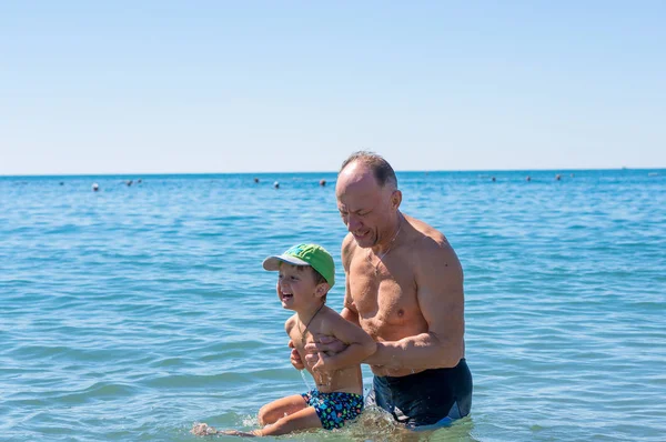 Abuelo y nieto jugando en el mar — Foto de Stock