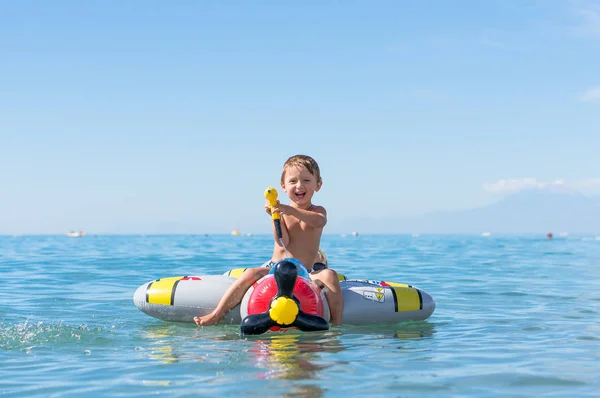Sonriente niñito jugando en el mar en el avión . — Foto de Stock