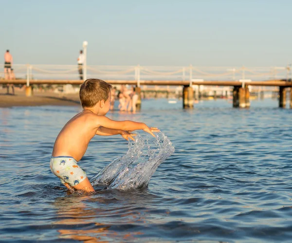 Усміхнений маленький хлопчик, який грає у морі. Позитивні людські емоції, почуття, радість . — стокове фото