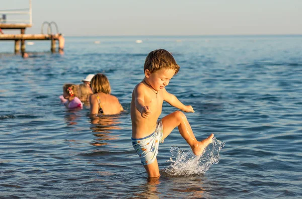 Χαμογελαστό μικρό αγόρι παίζει στη θάλασσα — Φωτογραφία Αρχείου