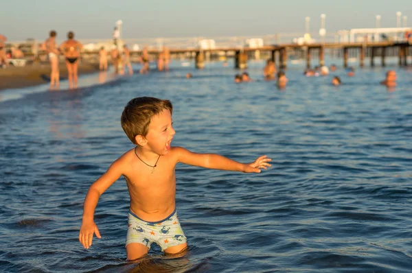 Χαμογελώντας μωρό αγοράκι παίζει στη θάλασσα. Θετικά ανθρώπινα συναισθήματα, συναισθήματα, χαρά. — Φωτογραφία Αρχείου