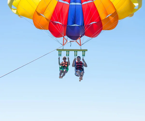 Casal feliz Parasailing na praia Dominicana no verão. Casal debaixo de paraquedas pendurado no ar. A divertir-me. Paraíso tropical. Emoções humanas positivas, sentimentos, alegria . — Fotografia de Stock