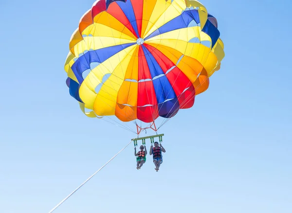 Glückliches Paar parasailing in Dominicana Strand Paar unter Fallschirm hängen in der Luft. Spaß haben. Tropisches Paradies. positive menschliche Emotionen, Gefühle, Freude. — Stockfoto