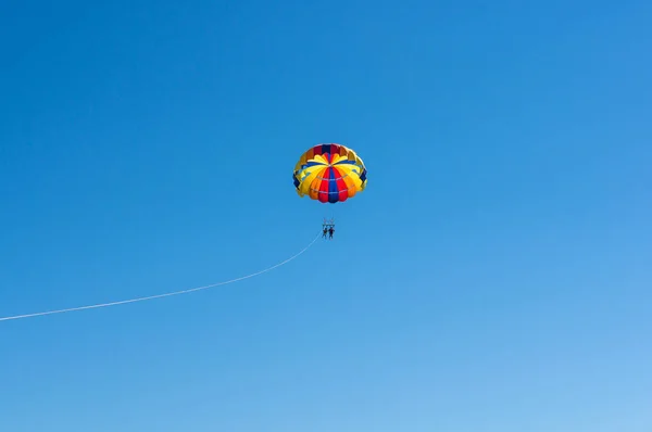 Gelukkig koppel Parasailing in Dominicana strand paar onder de parachute opknoping medio lucht. Plezier. Tropisch paradijs. Positieve menselijke emoties, gevoelens, vreugde. — Stockfoto