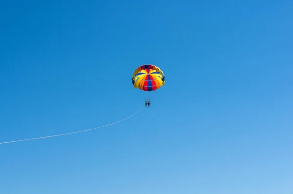 Szczęśliwa para Parasailing Dominicana Beach para pod spadochron wisi w powietrzu. Dobra zabawa. Tropikalny raj. Pozytywnych ludzkich emocji, uczuć, radości. — Zdjęcie stockowe