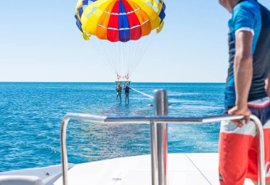 Mutlu çift Parasailing Dominicana içinde plaj yaz aylarında. İki orta hava asılı paraşüt altında. Eğleniyor. Tropik cenneti. Olumlu insan duyguları, duygular, sevinç.