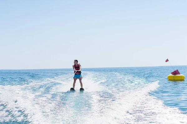 Mladý muž kluzáky na vodní lyžování na vlnách moře, oceán — Stock fotografie