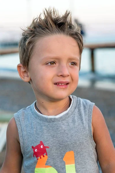 Denizde günbatımı üzerinde oynarken küçük boy gülümseyerek. Olumlu insan duyguları, duygular, joy. Mutlu küçük çocuk çocuk okyanus plaj portre. Yaz zevk tatil, yapma komik şirin çocuk.